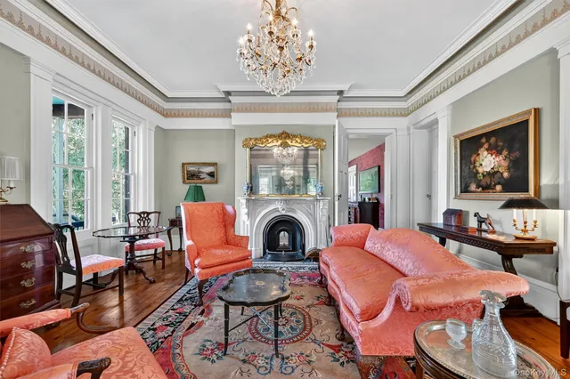 a living room with fireplace furniture and a chandelier