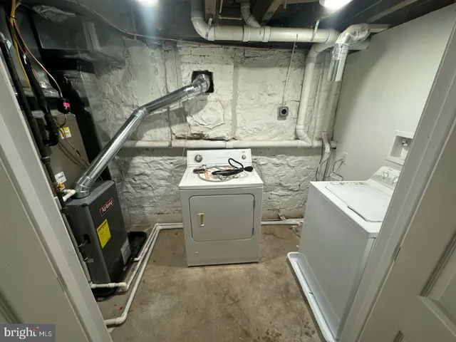 a utility room with dryer washer and stair