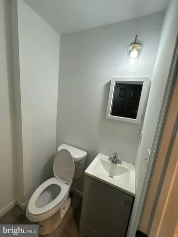 a bathroom with a toilet a sink and mirror