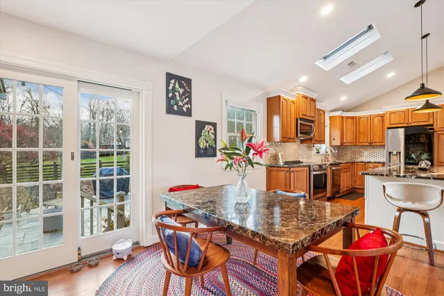 a dining room with wooden floor and chandelier