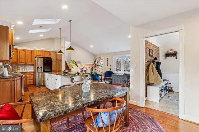 a kitchen with stainless steel appliances granite countertop a stove top oven a sink and dining table