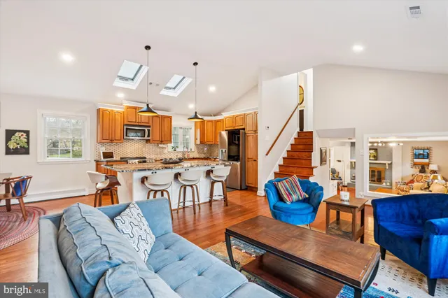 a living room with furniture kitchen view and a large window