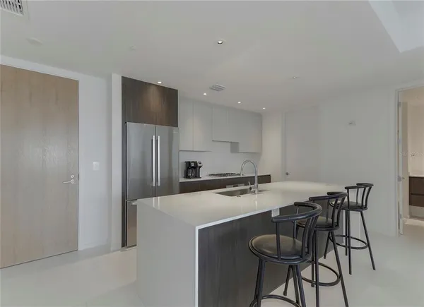 a kitchen with stainless steel appliances a table and chairs in it