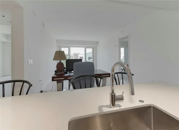 a kitchen with a faucet a sink and a stove with white countertops