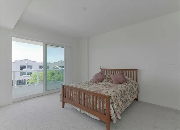 a bedroom with a bed and glass door