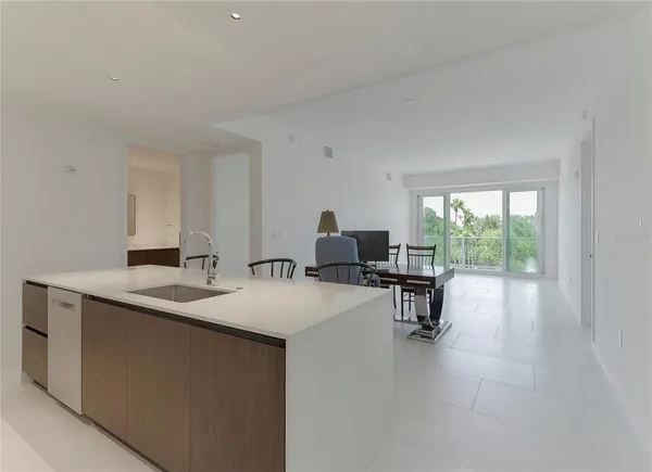 a kitchen with a sink and chairs
