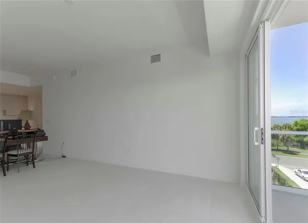 a view of room with wooden floor and furniture