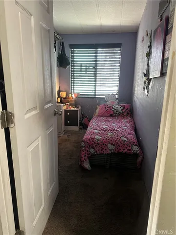 a bedroom with a bed next to a window