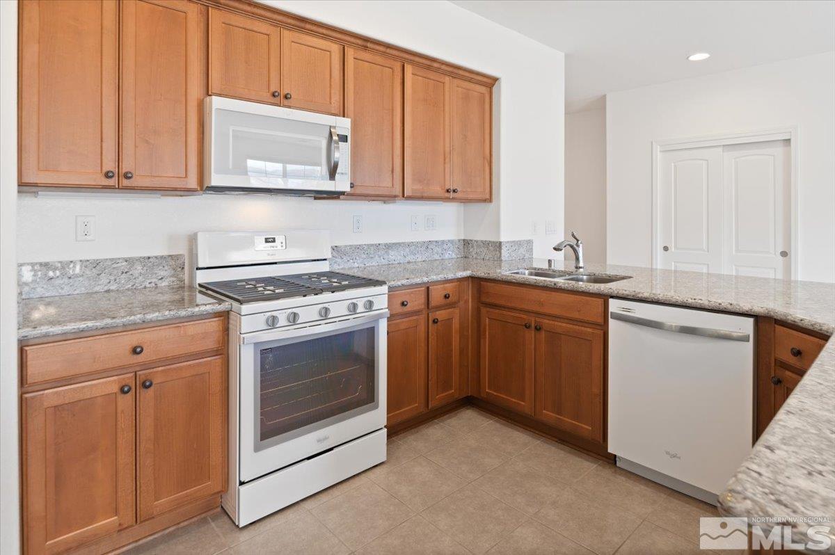 9700 Declan Drive Reno, NV 89521 - Photo 14 of 34 a kitchen with stainless steel appliances granite countertop a sink and cabinets with wooden floor