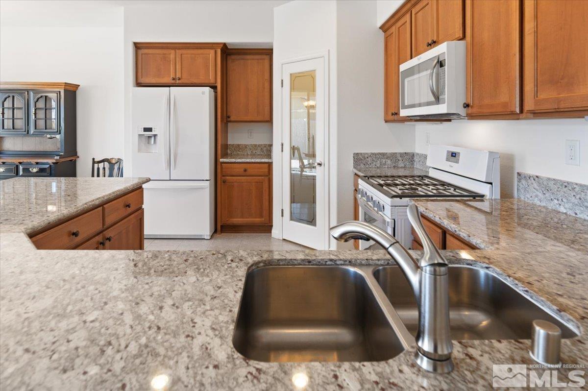 9700 Declan Drive Reno, NV 89521 - Photo 15 of 34 a kitchen with stainless steel appliances granite countertop a sink a stove and a refrigerator