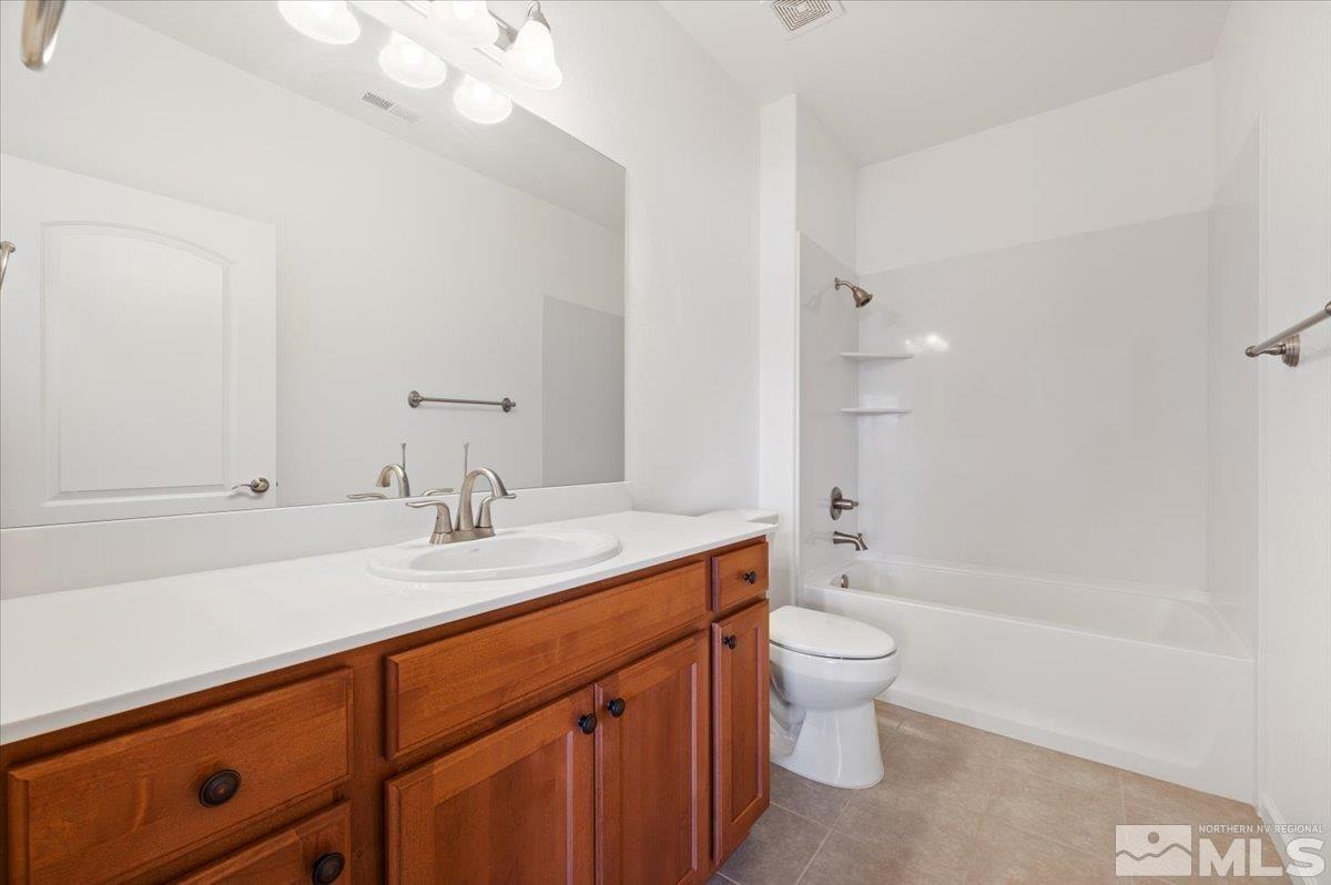 9700 Declan Drive Reno, NV 89521 - Photo 23 of 34 a bathroom with a sink a toilet and a large mirror