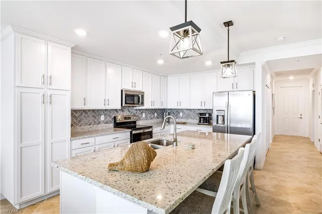 a kitchen with stainless steel appliances granite countertop a sink refrigerator and microwave