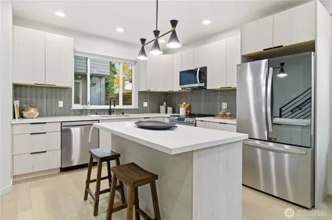 a kitchen with white cabinets and stainless steel appliances
