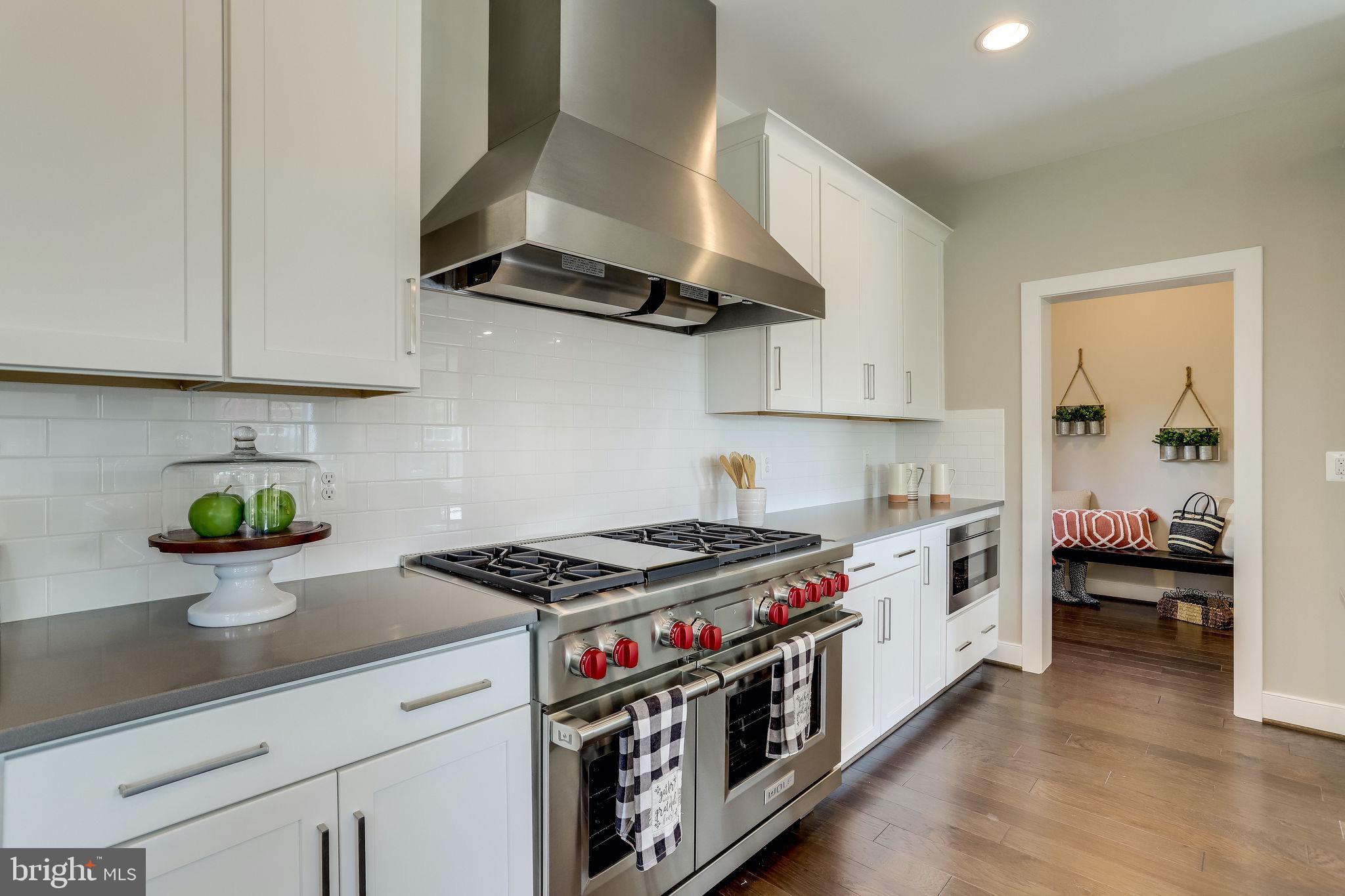 a kitchen with stainless steel appliances a stove a white cabinets and a counter top space