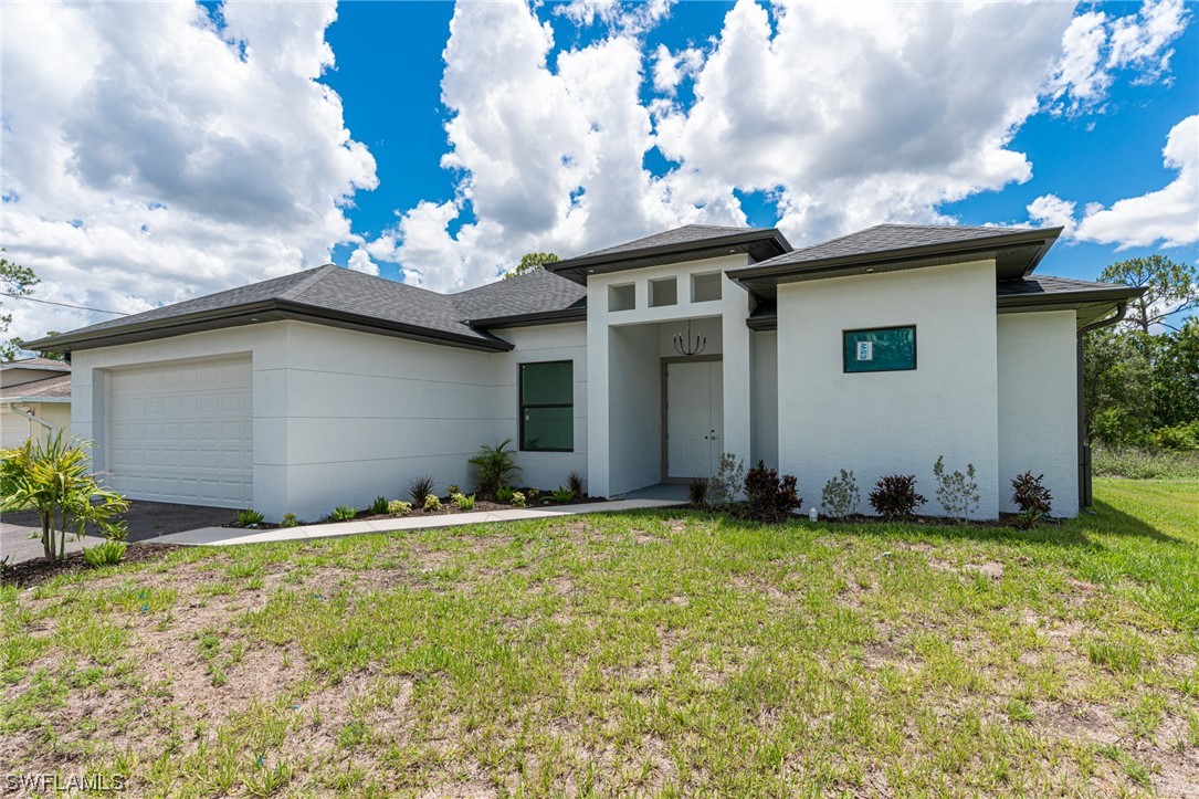 346 Rancho Avenue Lehigh Acres, FL 33974 - Photo 1 of 24 a backyard of a house with table and chairs