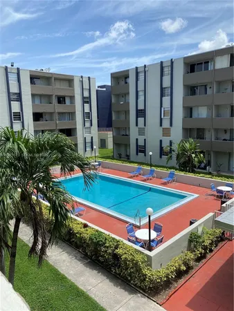 a view of a backyard with swimming pool and sitting area