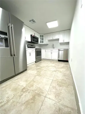a kitchen with stainless steel appliances granite countertop a refrigerator sink and cabinets