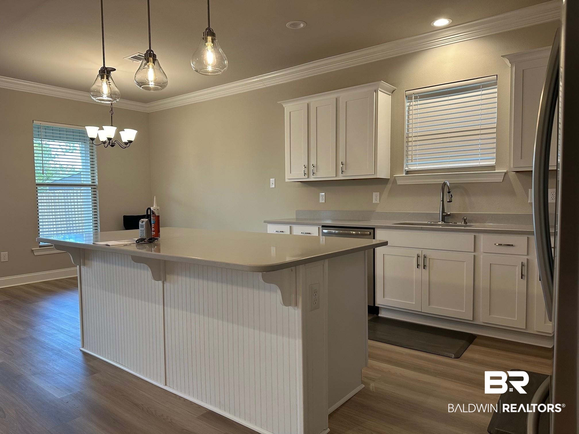 1009 Ruisseau Drive Foley, AL 36535 - Photo 21 of 55 Kitchen featuring white cabinetry, stainless steel refrigerator, a center island, and hanging light fixtures
