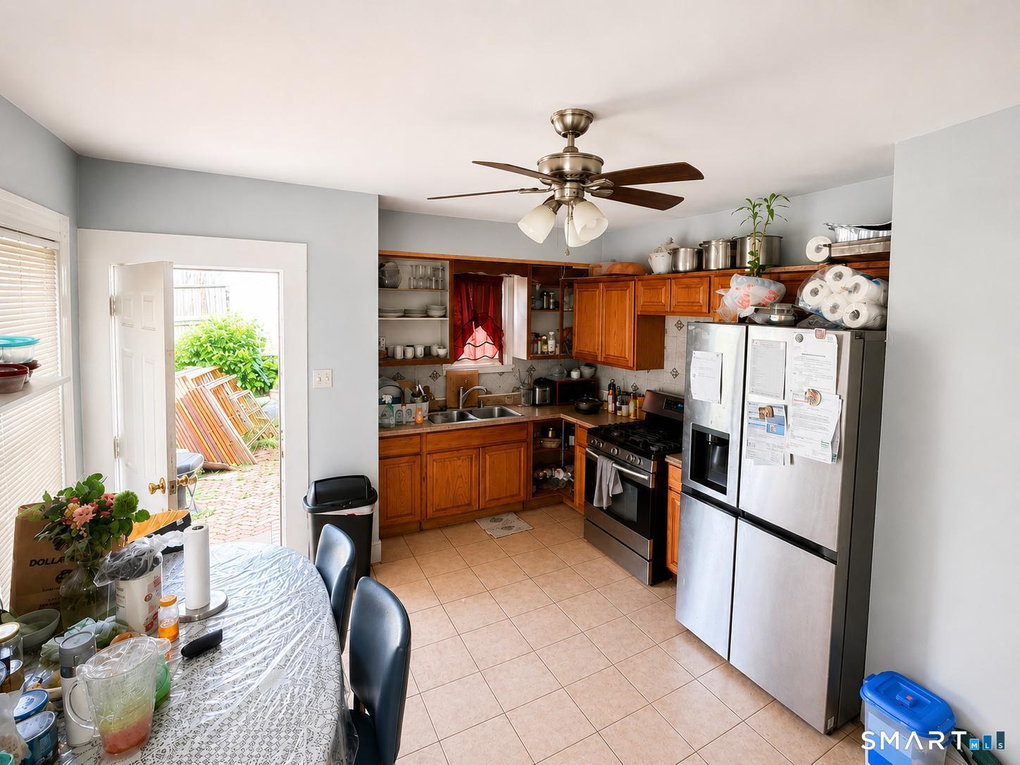 98 Huntington Road Bridgeport, CT 06608 - Photo 5 of 15 a kitchen with stainless steel appliances granite countertop a refrigerator a sink dishwasher a stove and a dining table with wooden floor