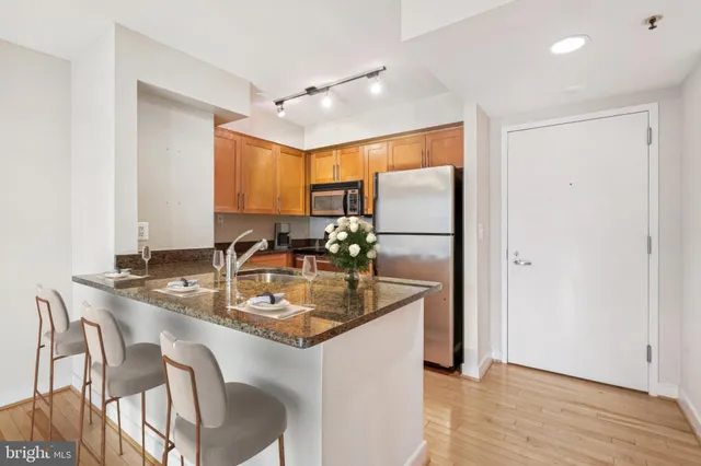 a kitchen with stainless steel appliances granite countertop a sink refrigerator and microwave