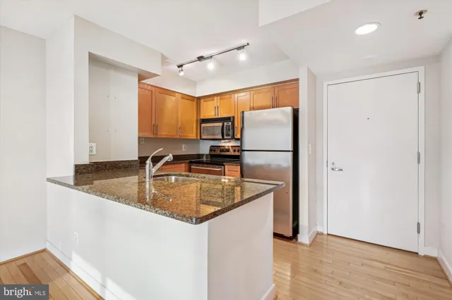 a kitchen with stainless steel appliances granite countertop a refrigerator a sink and a stove