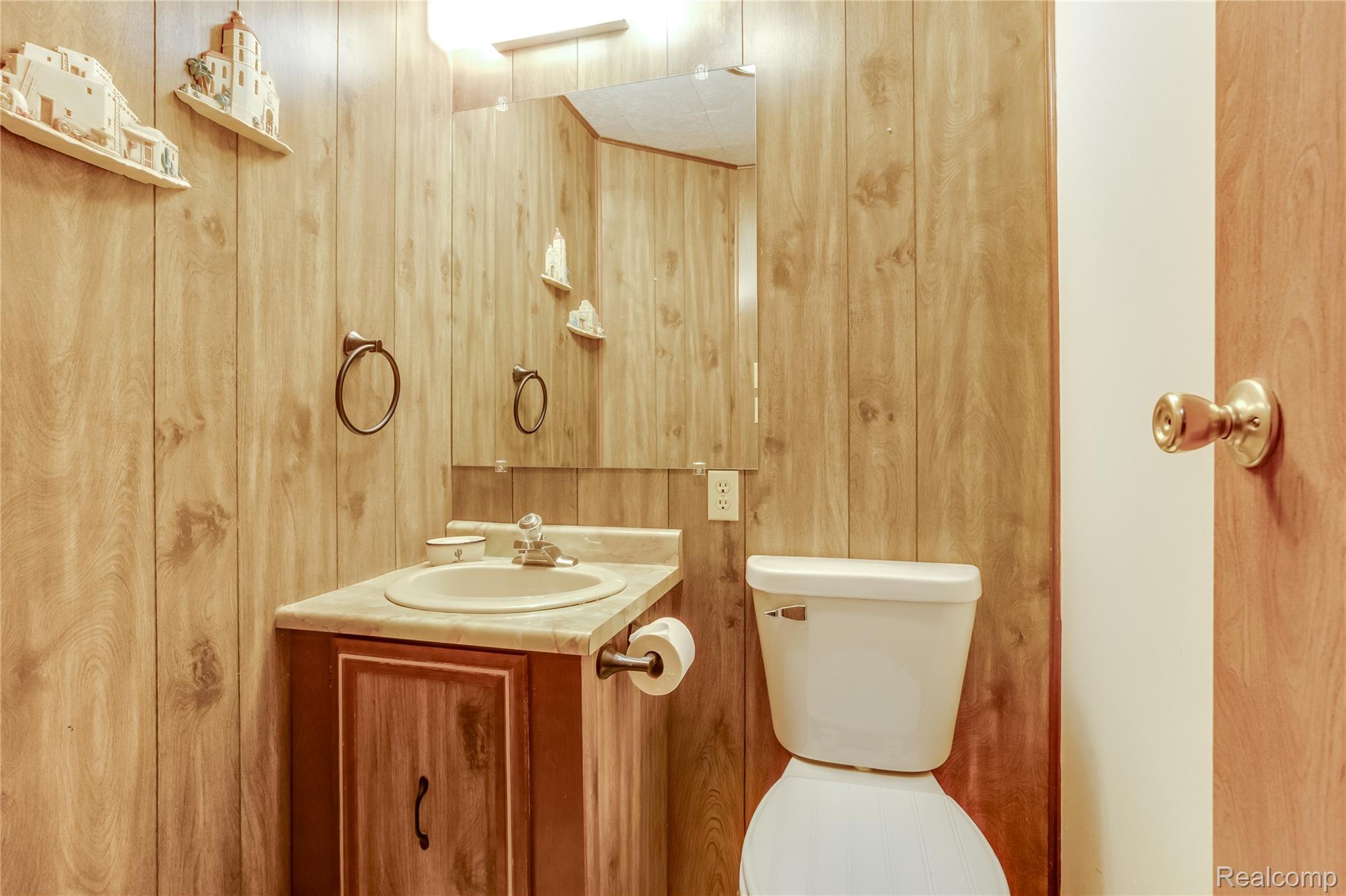 3333 Ravenswood Road Marysville, MI 48040 - Photo 19 of 25 Half bath with vanity and wooden walls