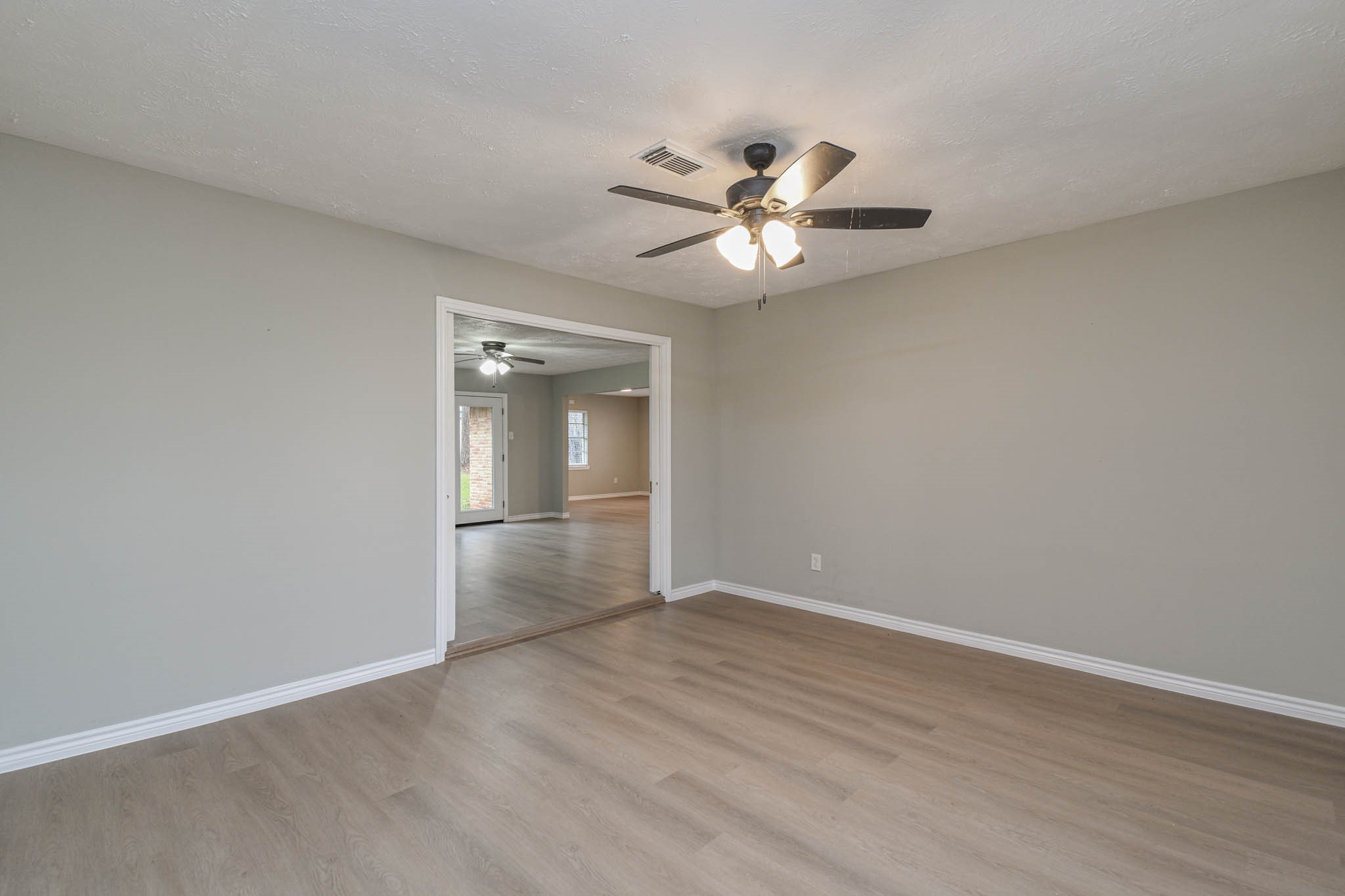 2834 Pansy Street Pasadena, TX 77503 - Photo 4 of 30 Front Room with Pocket Doors for Privacy from the Main Living Area. Notice the Updated Vinyl Plank Floors that are Consistent throughout the Whole Home.