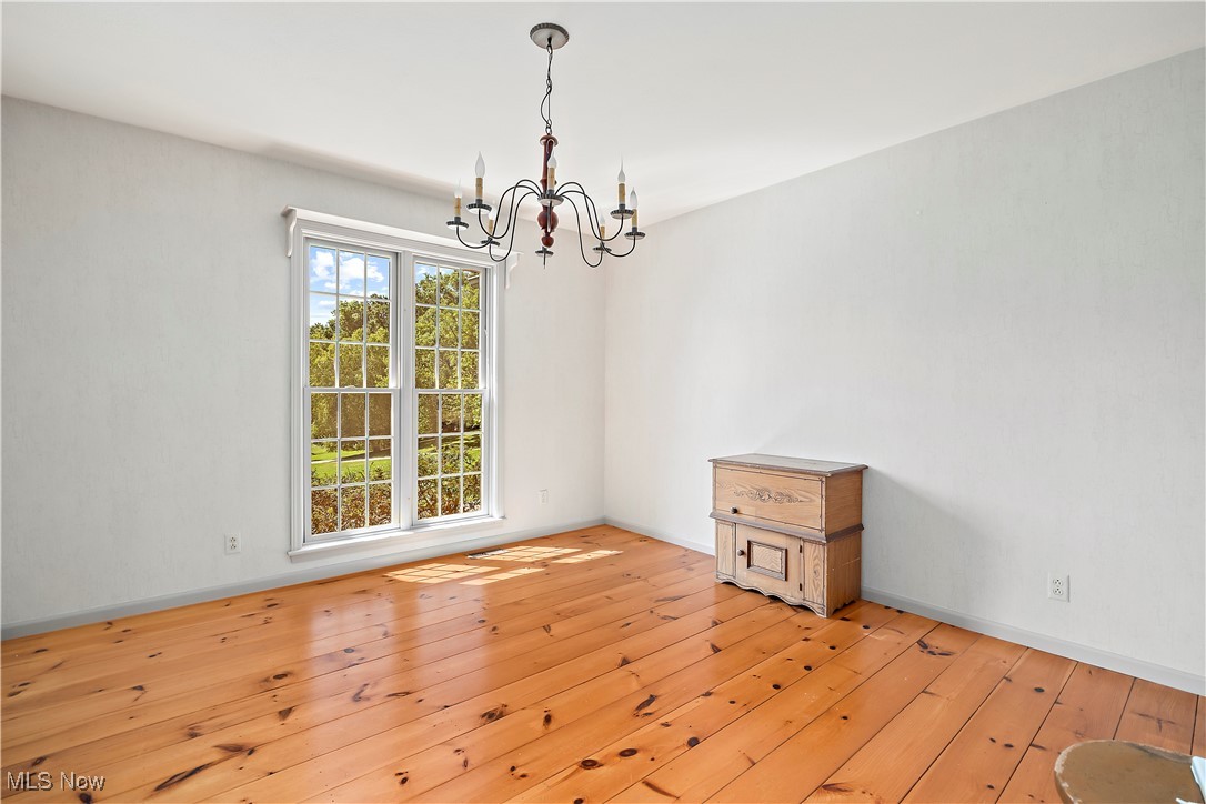 13901 Shaw Mill Road Milan, OH 44846 - Photo 10 of 42 Unfurnished room featuring light hardwood / wood-style flooring and an inviting chandelier