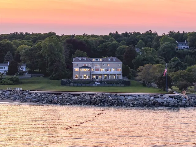 a view of a house with a yard and a large tree