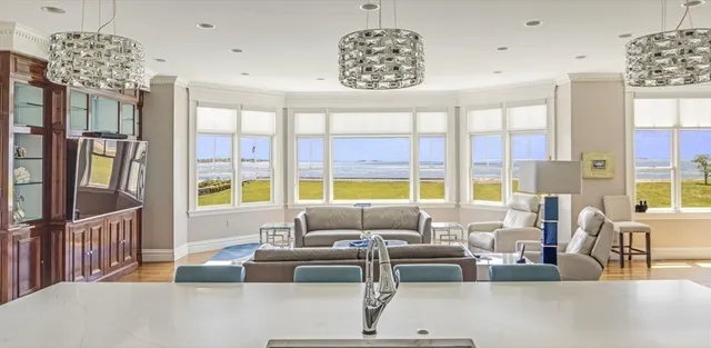 a dining hall with stainless steel appliances granite countertop a stove and a wooden floors