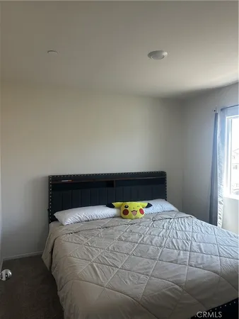 a bed sitting in a bedroom next to a window