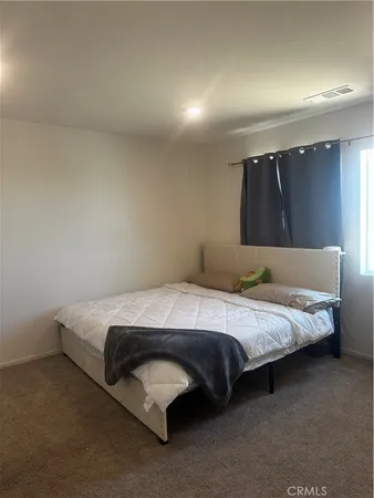 a bedroom with a bed and a night stand