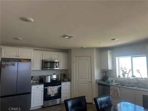 a kitchen with stainless steel appliances granite countertop a refrigerator sink and stove