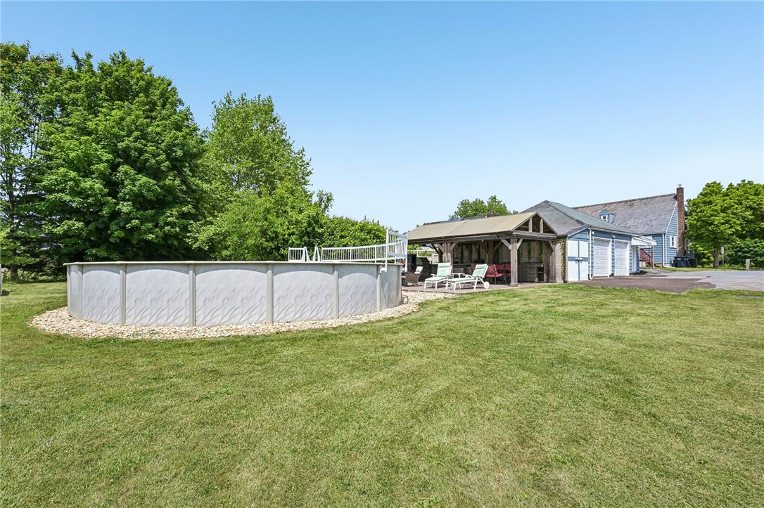 4065 Airport Road Allentown, PA 18109 - Photo 25 of 28 Enjoy outdoor leisure with a spacious above-ground pool, covered patio, and verdant surroundings.