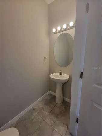 a bathroom with a sink toilet and a mirror