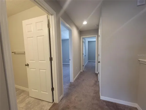 a view of a hallway with closet and bathroom