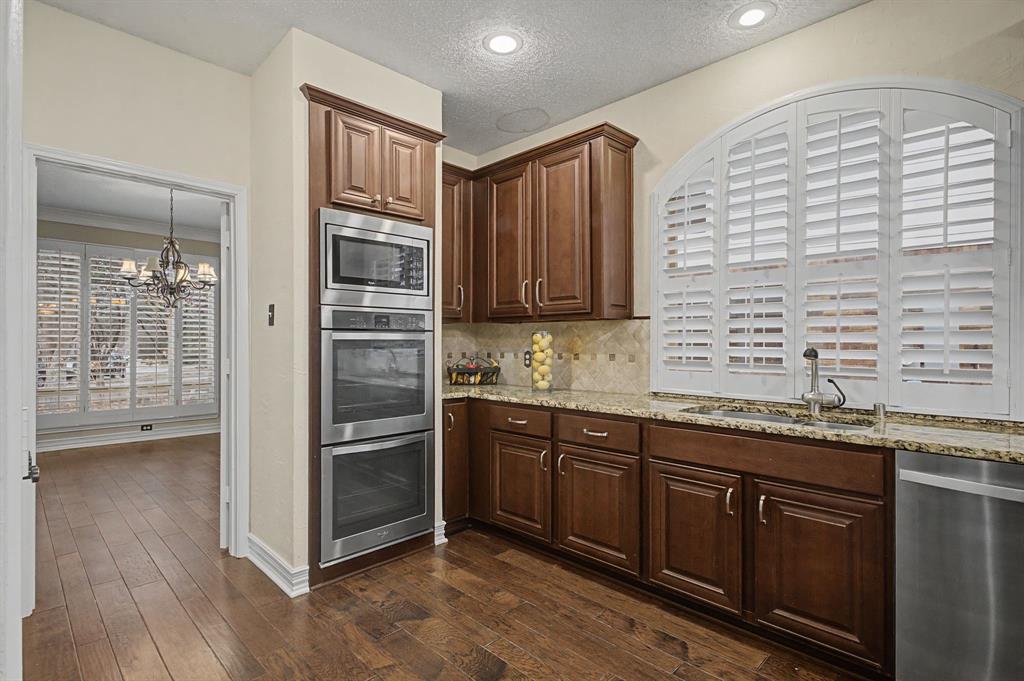 2705 Wind Ridge McKinney, TX 75072 - Photo 17 of 40 a kitchen with stainless steel appliances granite countertop a stove a sink and a refrigerator