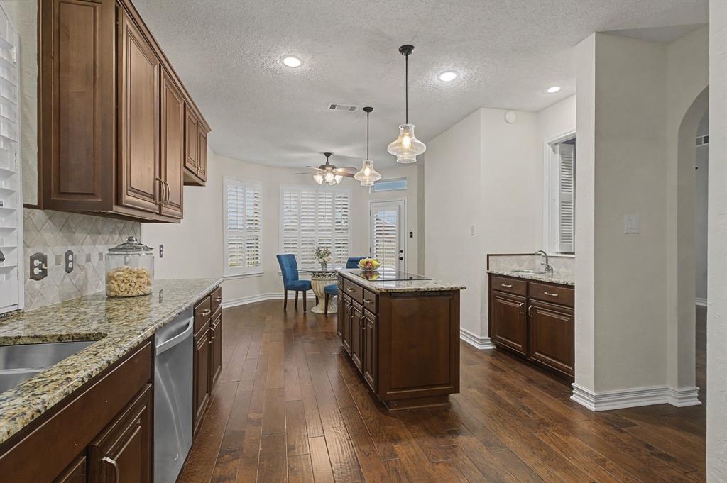 2705 Wind Ridge McKinney, TX 75072 - Photo 19 of 40 a kitchen with granite countertop a stove a sink a refrigerator and wooden floor
