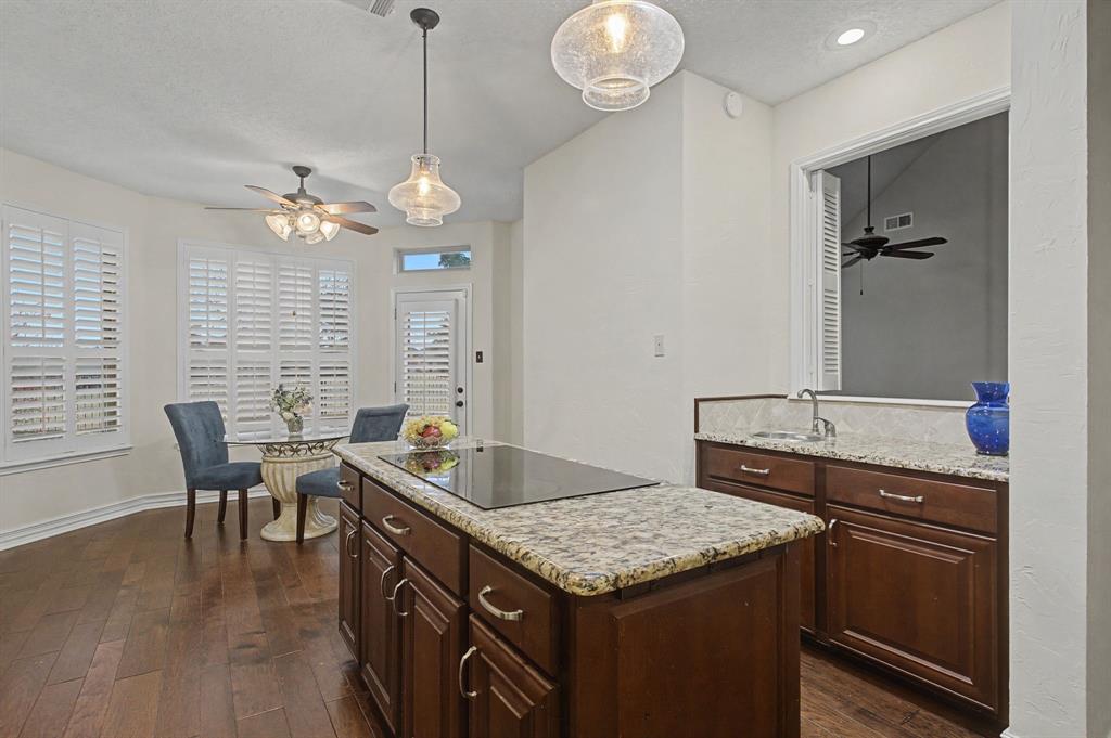 2705 Wind Ridge McKinney, TX 75072 - Photo 20 of 40 a kitchen with granite countertop stove a dining table and chairs