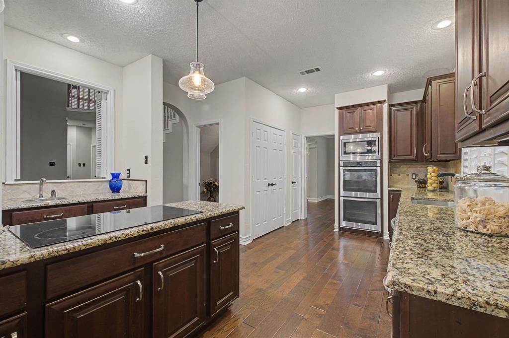 2705 Wind Ridge McKinney, TX 75072 - Photo 21 of 40 a large kitchen with kitchen island a sink stainless steel appliances and a counter top space