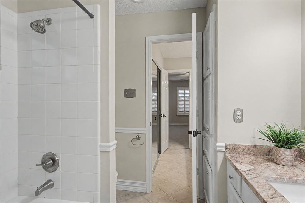 2705 Wind Ridge McKinney, TX 75072 - Photo 36 of 40 a spacious bathroom with a granite countertop sink a mirror and shower