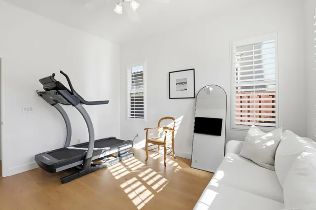 a living room with furniture gym equipment and a window