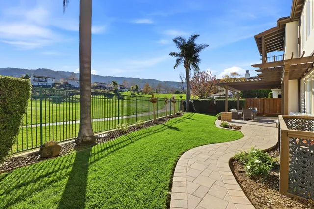 a view of a house with a yard and table and chairs under an umbrella