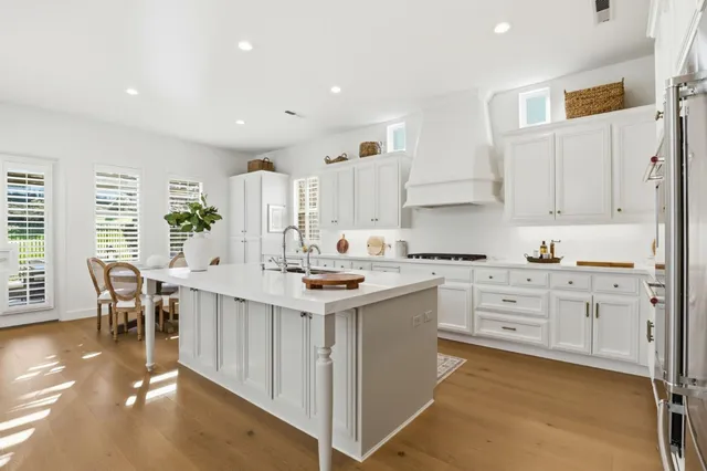 a kitchen with white cabinets sink and stove