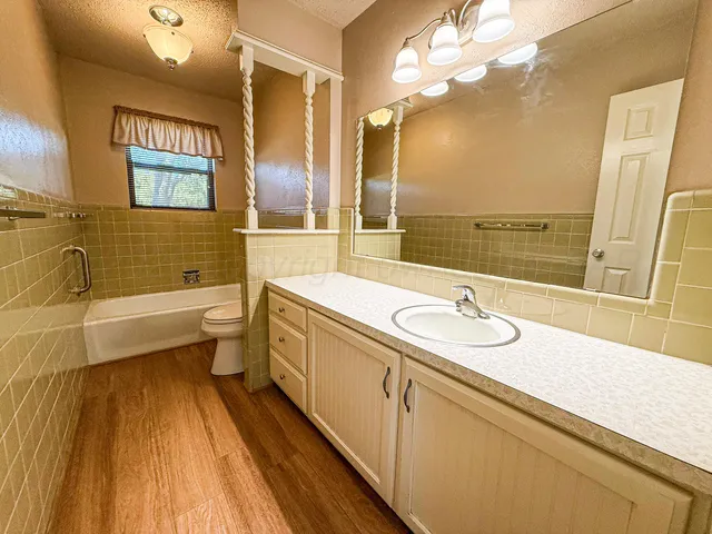 a bathroom with a sink a large mirror and a bathtub