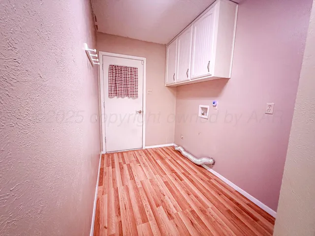 a view of a room with wooden floor and cabinet