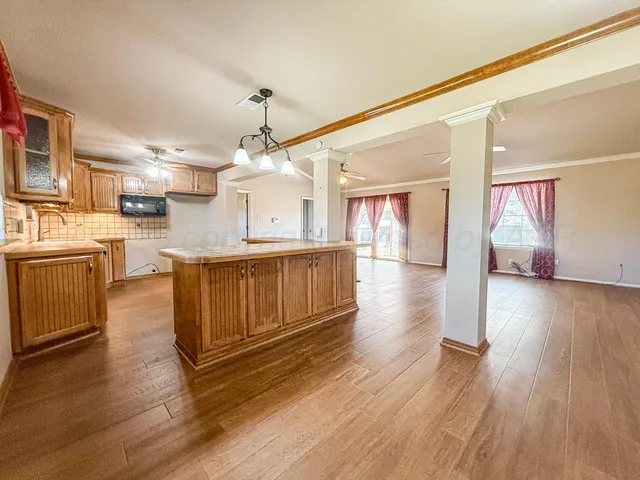 a large kitchen with cabinets wooden floor and stainless steel appliances