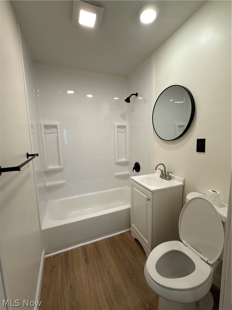 4841 Marigold Road Mentor, OH 44060 - Photo 8 of 12 Bathroom featuring a white bathtub with a shower kit, a single vanity with a basin sink, and wood-finish flooring
