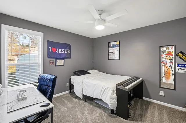 a bedroom with a bed and a dresser next to a window