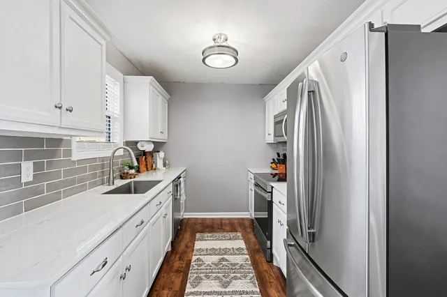 a kitchen with sink a refrigerator and cabinets